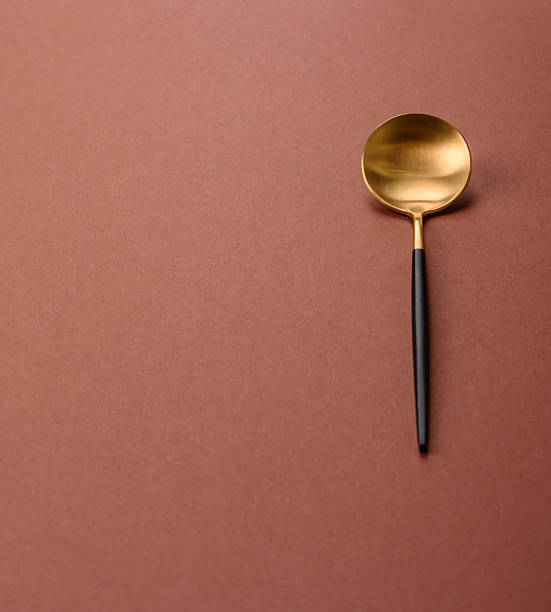 istock Empty metal spoon on a monochrome brown background 2210218572
