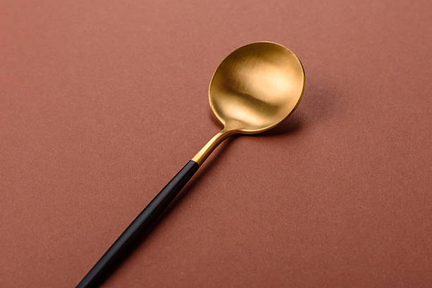 istock Empty metal spoon on a monochrome brown background 2210218575