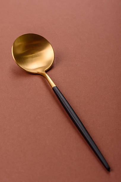 istock Empty metal spoon on a monochrome brown background 2210218583