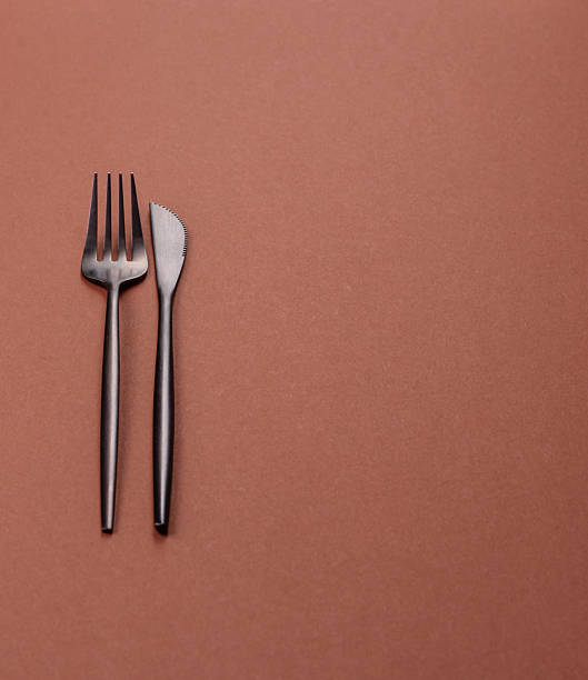 istock Knife and fork, cutlery on a brown dining table 2210219333