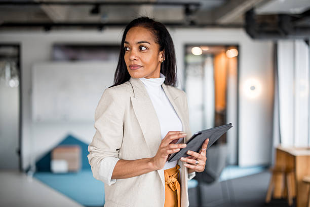 istock Confident Hispanic Businesswoman Analyzing Data on Tablet 2210220934