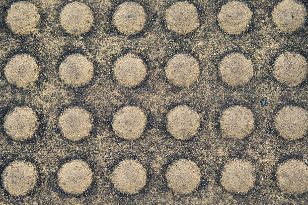 The embossed round shape on yellow concrete road textured background