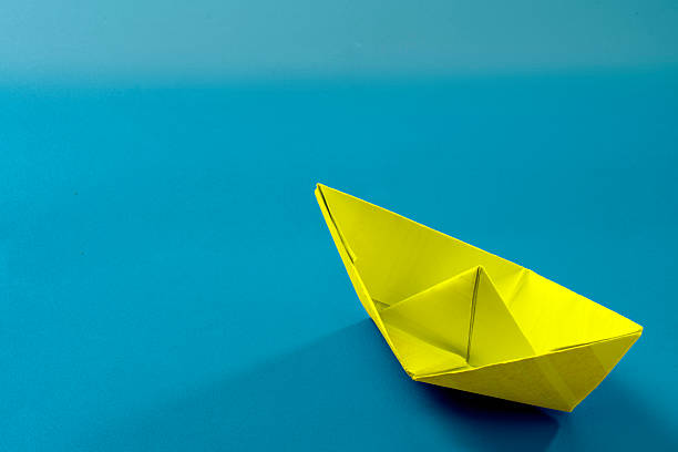 istock Origami boat from yellow paper 2210223559