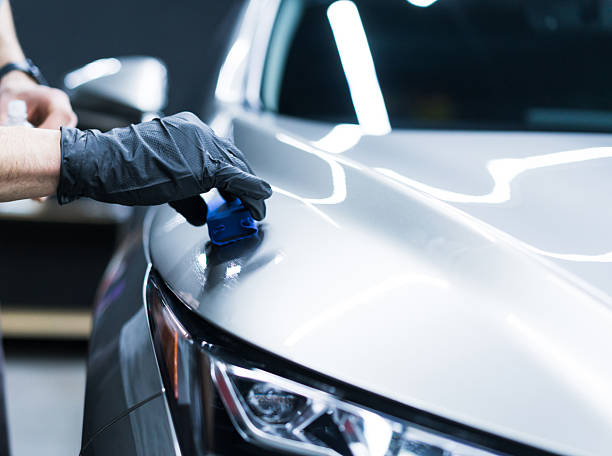 Car detailing, polishing car. Close-up of a gloved hand applying nano coating on a car.