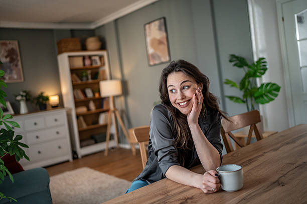 istock Happy woman drinking coffee in modern apartment 2210225717