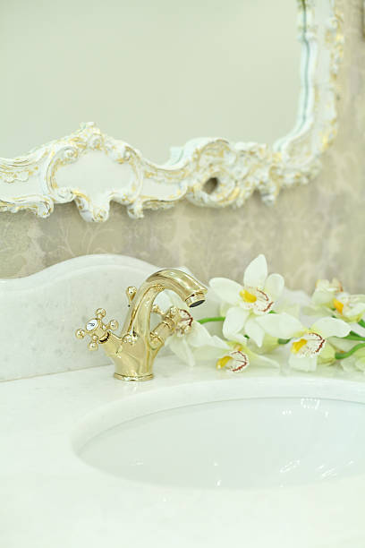 istock Bathroom background, interior detail. Gold faucet on white stone surface 2210228172