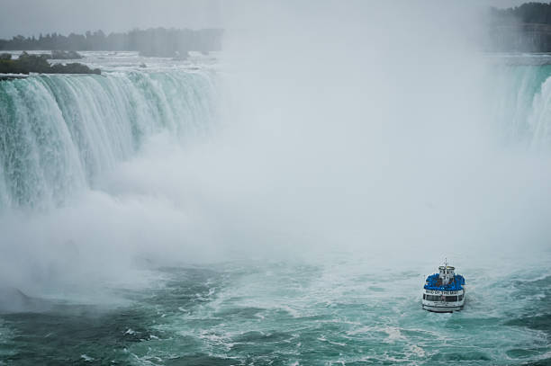 Niagara Falls, Ontario, Canada  - September, 1, 2019: A boat tour beneath Horseshoe Falls at Niagara Falls on a cloudy day