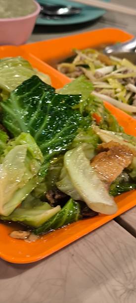 istock Stir-fried morning glory and crispy pork on an orange plate 2210229326