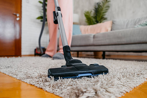istock Young Woman Vacuuming Her Apartment 2210234238