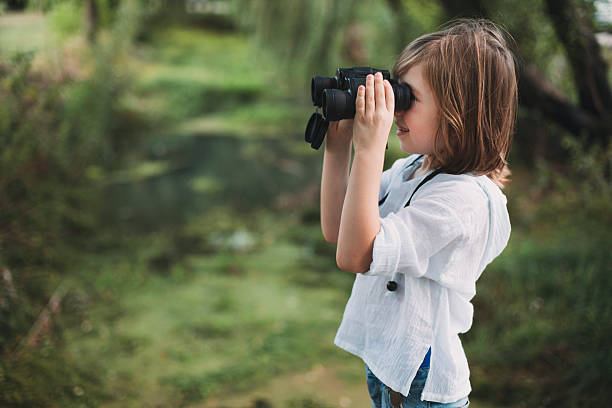 istock Cute child with binoculars in nature 2210237415