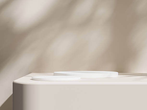 istock Simple white podiums with tree shadows stretching across the smooth beige surface. 2210241624