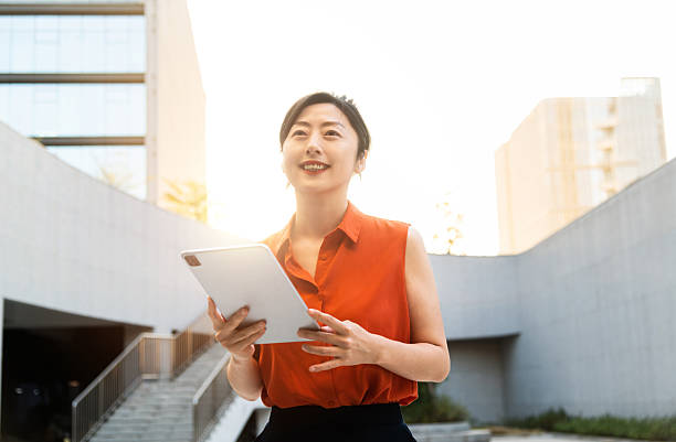 istock Businesswoman using digital tablet outside the office building 2210242392