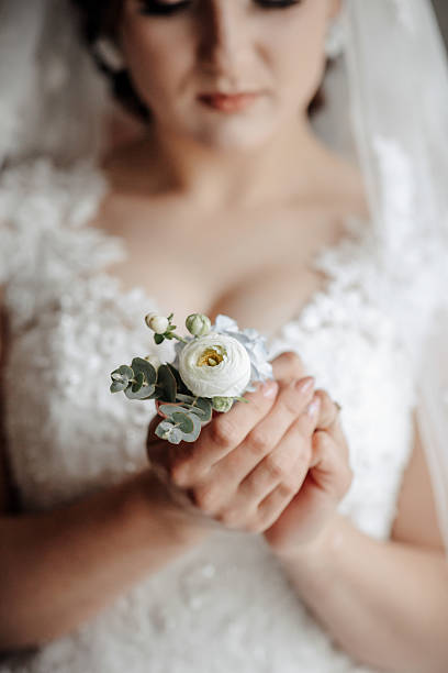 istock A bride is holding a flower in her hand 2210243313