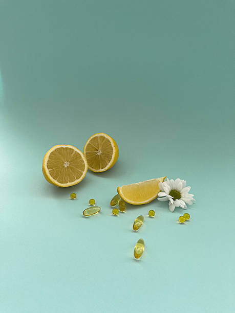 istock Fresh lemon slices and vitamin capsules with a daisies on turquoise background 2210244161