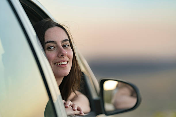 istock Woman in car window at sunset 2210244251