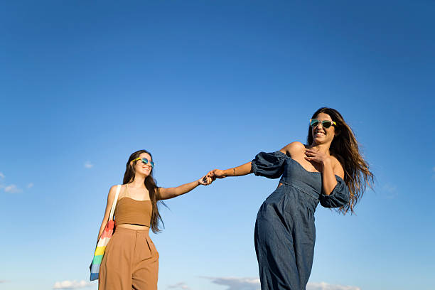 istock Lesbian couple holding hands with sky in the background 2210244322