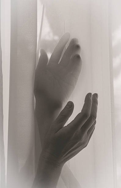 istock Woman's hands visible through nylon fabric, black and white photo 2210246773