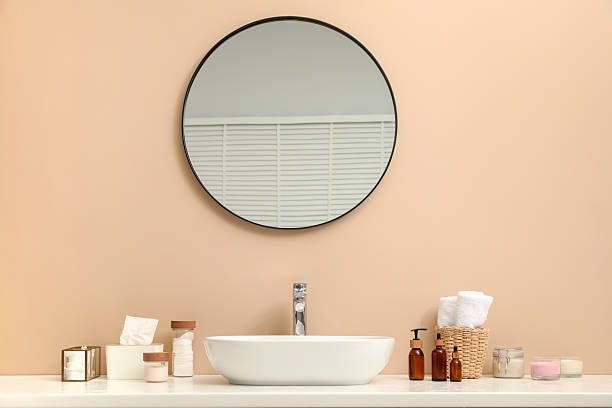 istock Countertop with sink, toiletries and mirror in bathroom 2210247668