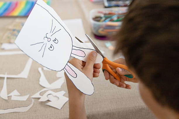 istock A child carefully cuts out his or her bunny, practicing fine motor skills, scissor control, and autonomy through a creative activity. 2210249816