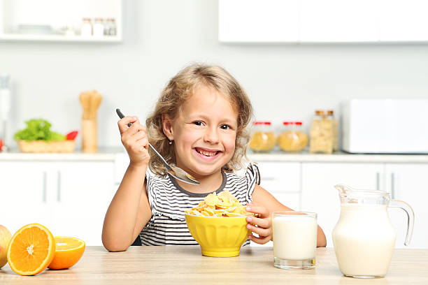 istock Little girl eating cornflakes with milk 2210250584