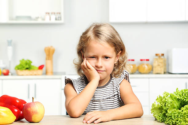 istock Little girl sitting in the kitchen 2210251597