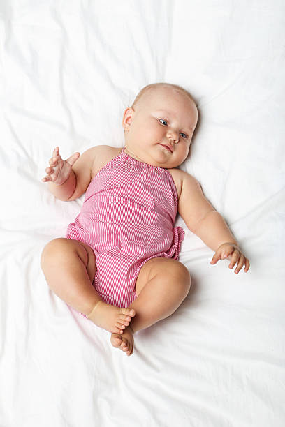 istock Little newborn baby on white bed 2210252045