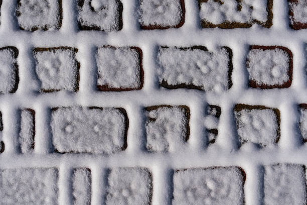 istock White snow on the paving slabs covered with a thin layer of fallen white snow, closeup, top view 2210252855