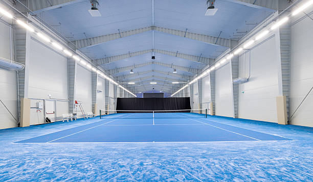istock Spacious Indoor Tennis Court With Blue Surface and Modern Lighting 2210253812