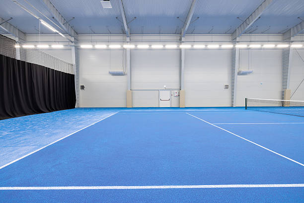 istock Modern Indoor Tennis Court With Blue Playing Surface And Bright Lighting 2210254597