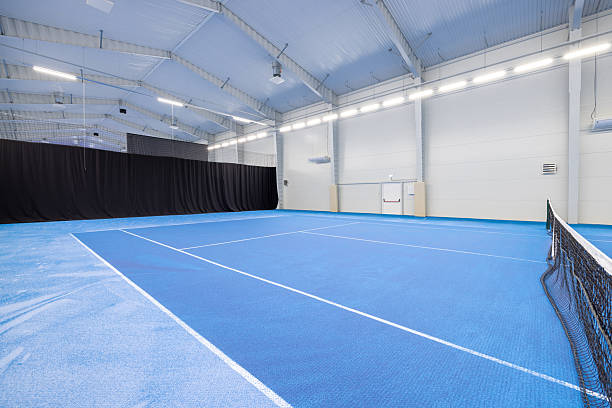 istock Modern Indoor Tennis Court With Blue Playing Surface And Bright Lighting 2210254641