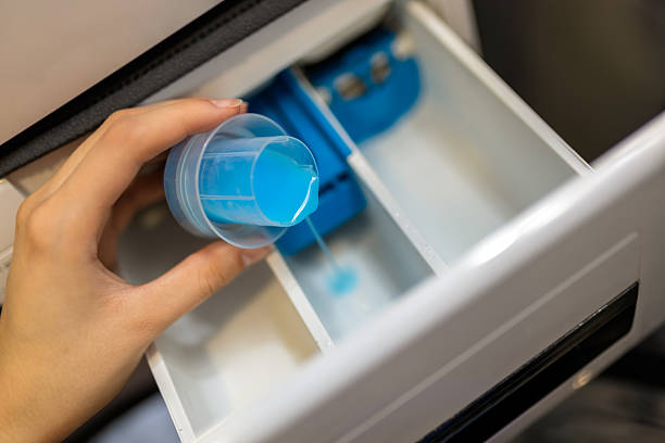 istock Woman puts softener in the washing machine. 2210261006