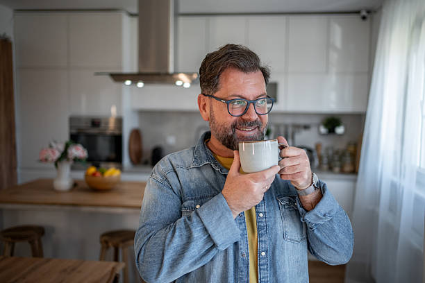istock Smiling mature man drinking coffee in modern kitchen 2210261049