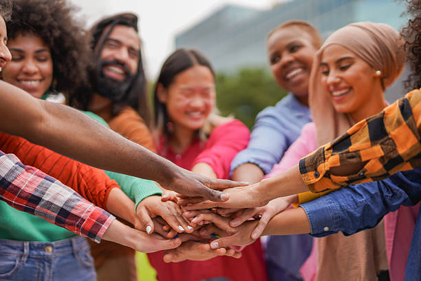 istock Crowd of multiracial people stacking hands outdoor - Diverse students celebrating success outdoor - Teamwork and unity concept - Focus on hands 2210261093