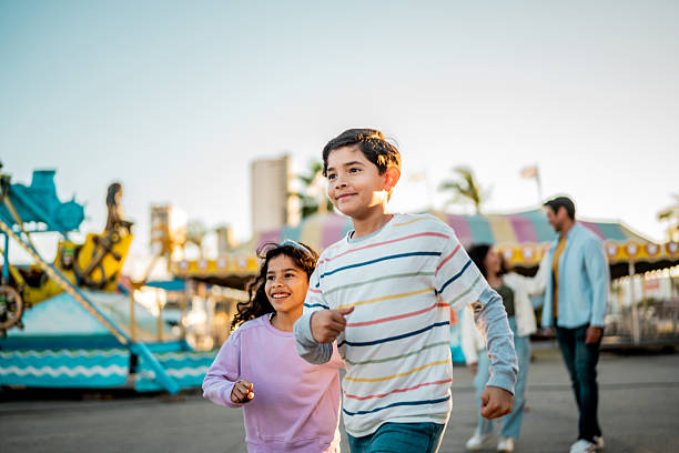 istock Child siblings running on amusement park 2210265467
