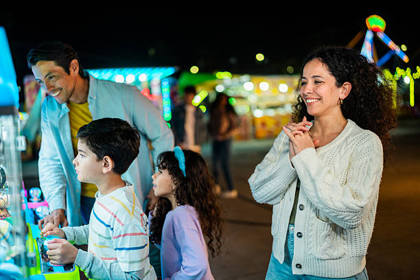 istock Family playing on push machine at amusement park 2210265534