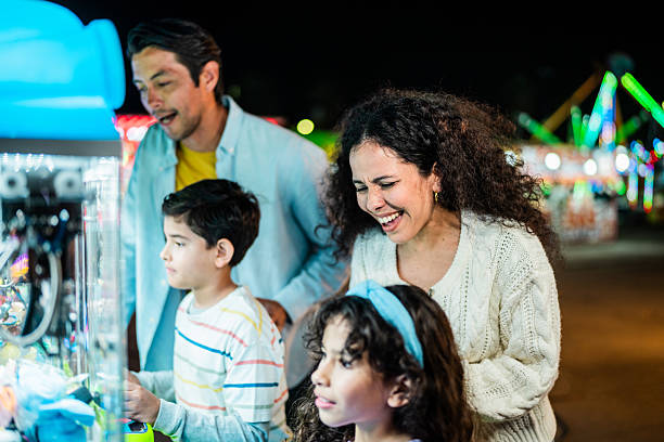 istock Family playing on push machine at amusement park 2210265541