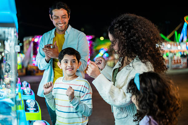 istock Family playing on push machine at amusement park 2210265543