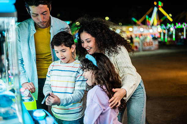istock Family playing on push machine at amusement park 2210265544