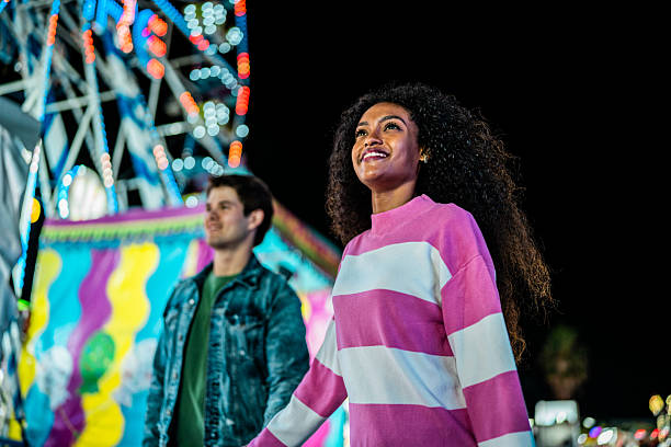 istock Young couple walking at amusement park 2210266119