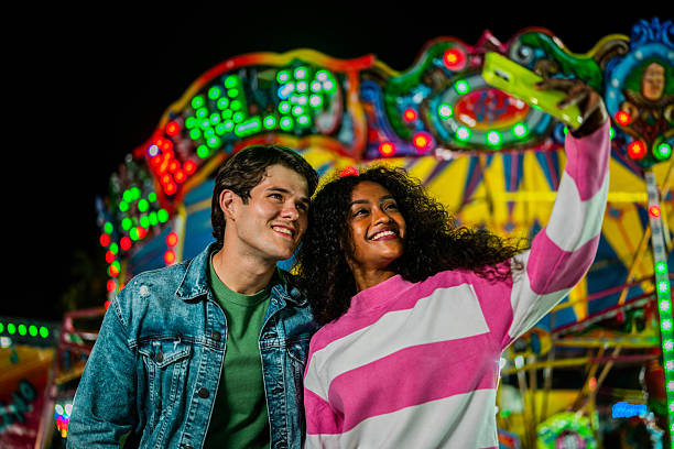 istock Young couple taking a selfie at amusement park 2210266246