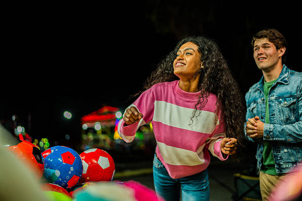 istock Young couple playing dart at amusement park 2210266345