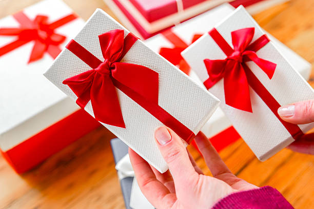 istock Hands Holding Gift Box with Red Ribbon 2210266389