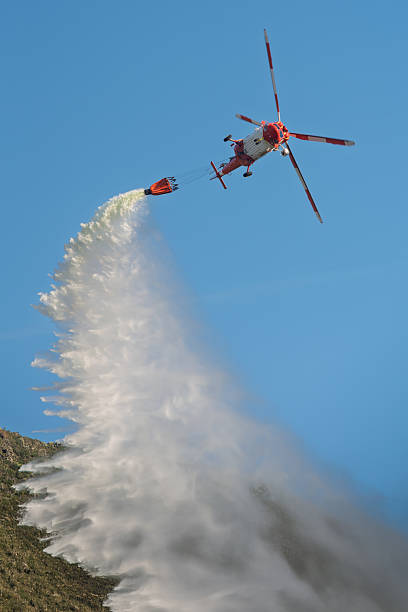 istock Firefighting helicopter dropping water from Bambi bucket 2210266675
