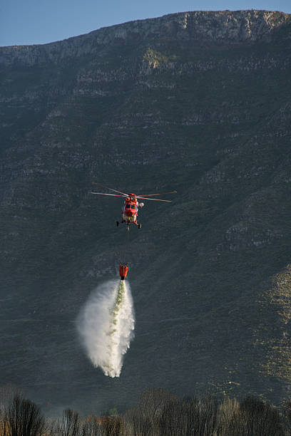 istock Fire fighting helicopter releasing water from bucket 2210266808