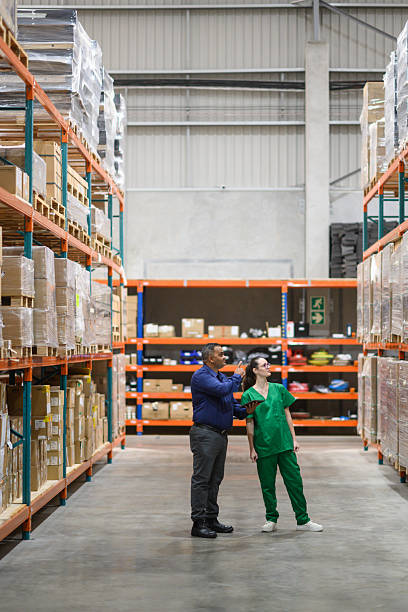 istock Manager and assistant examining stock inventory in a medical warehouse 2210267101