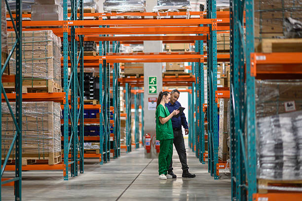 istock Manager and staff checking inventory in an organized warehouse 2210267176