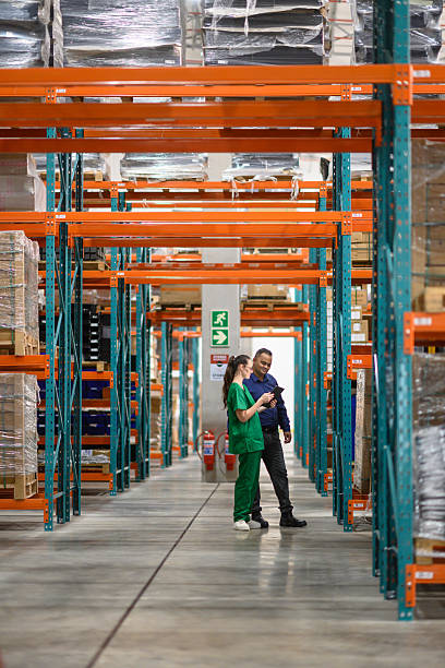 Manager and staff discussing inventory in a modern warehouse setting