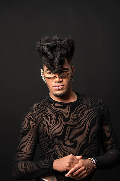 istock Young androgynous man with styled hair and jewelry posing in studio 2210267976