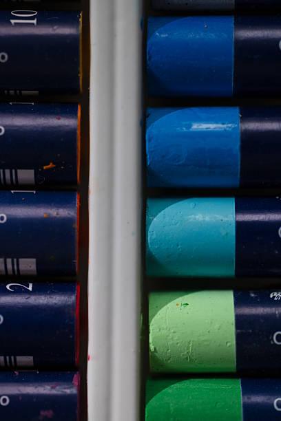 A neatly organized box of oil pastels in a variety of vivid colors, aligned in rows inside a white tray. Ideal for themes related to education, creativity, and artistic preparation.