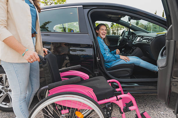 istock Young woman with cerebral palsy prepares to exit car with assistant’s help 2210269324
